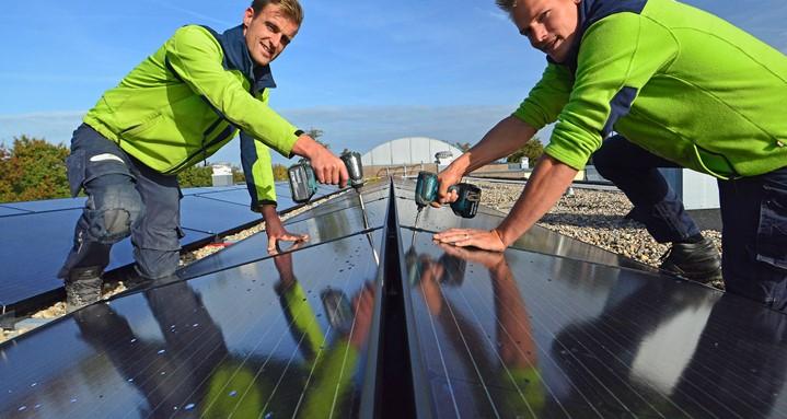 2 installatiemonteurs monteren zonnepanelen op dak