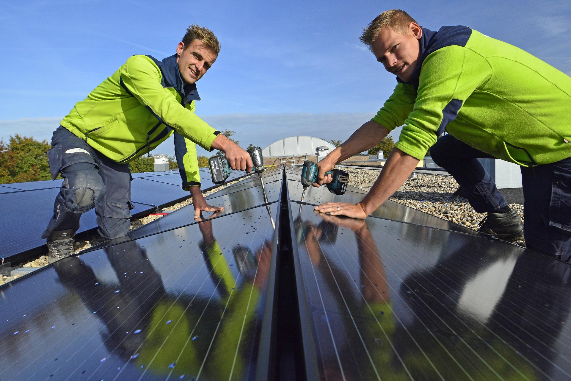 2 installatiemonteurs monteren zonnepanelen op dak